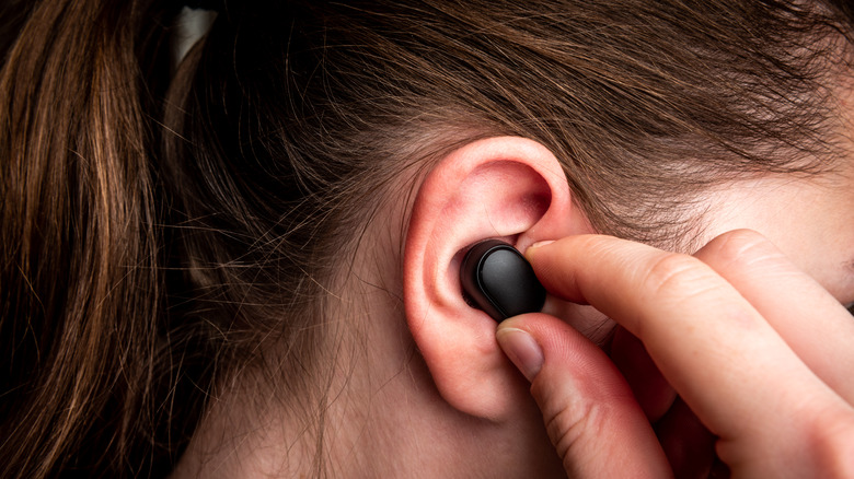 Person wearing black earbuds