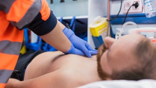 Un urgentise réalise un massage cardiaque à un patient victime de crise cardiaque.